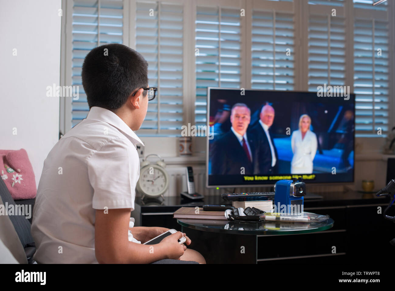 Bebrillte junge TV zu Hause beobachten Stockfoto