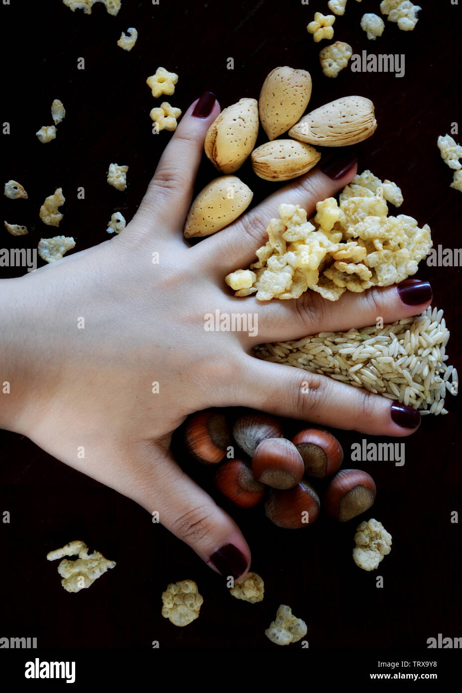 Körner, Nüsse und Getreide auf dem Tisch mit Frauen Hände Stockfoto