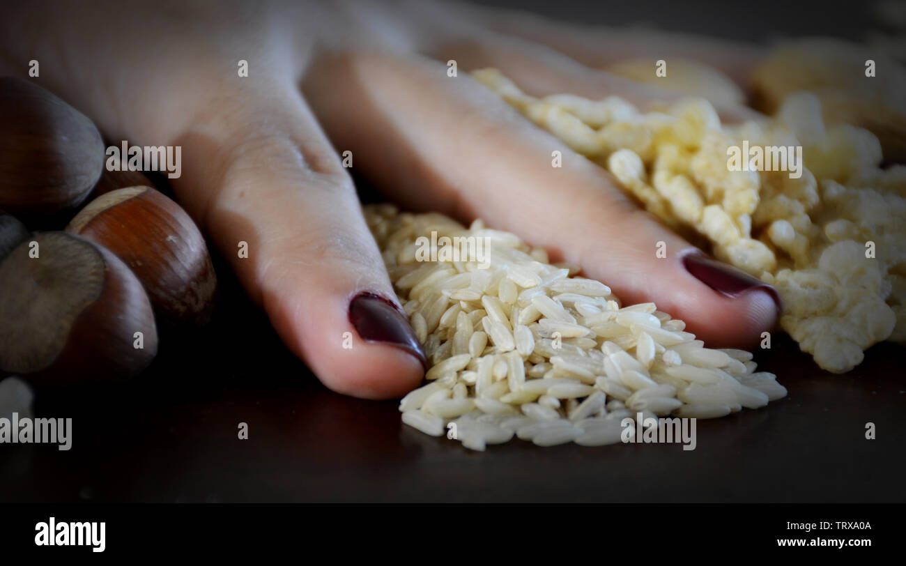 Körner, Nüsse und Getreide auf dem Tisch mit Frauen Hände Stockfoto