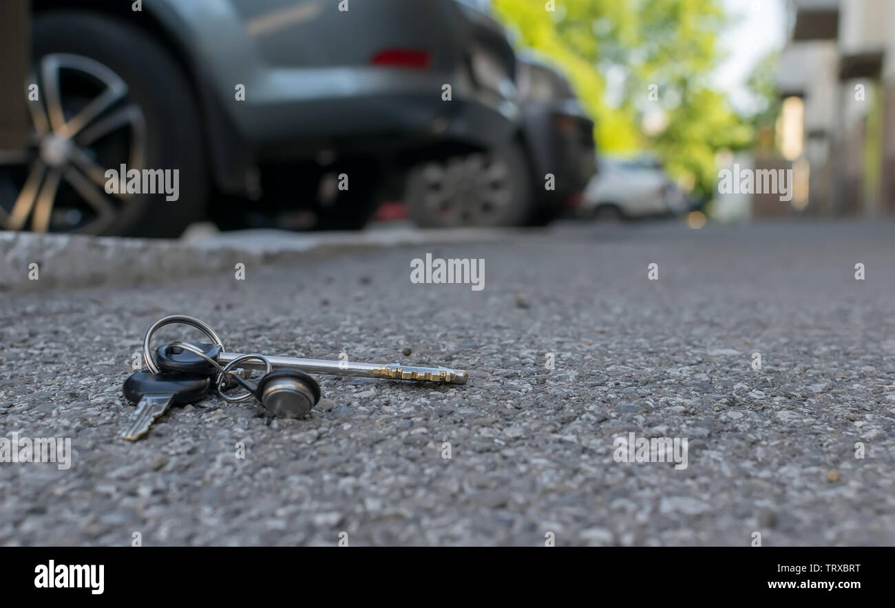 Die verlorenen Schlüsselbund liegt auf der asphaltierten Gehweg der Straße, in der Nähe der Eingang eines Hauses, die mit dem geparkten Autos Stockfoto