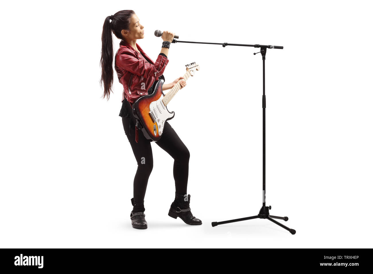 Volle Länge Schuß eines weiblichen Rock Musiker mit einer Gitarre Gesang auf ein Mikrofon auf weißem Hintergrund Stockfoto