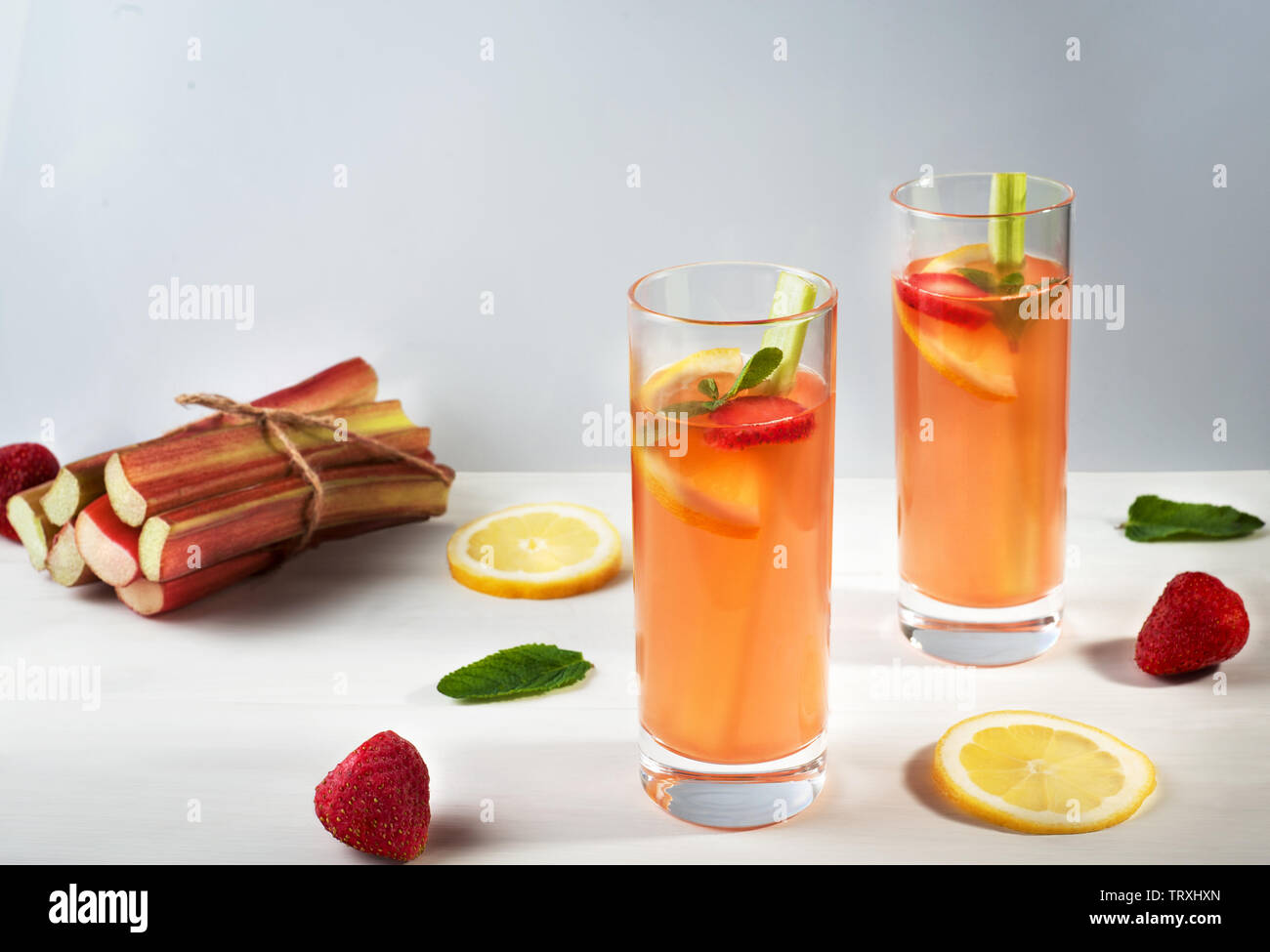 Hausgemachte bio Limonade mit Erdbeeren, Rhabarber und und Minze in zwei Gläser auf den hölzernen Hintergrund. Gesunde natürliche aromatisierte Getränk. Stockfoto