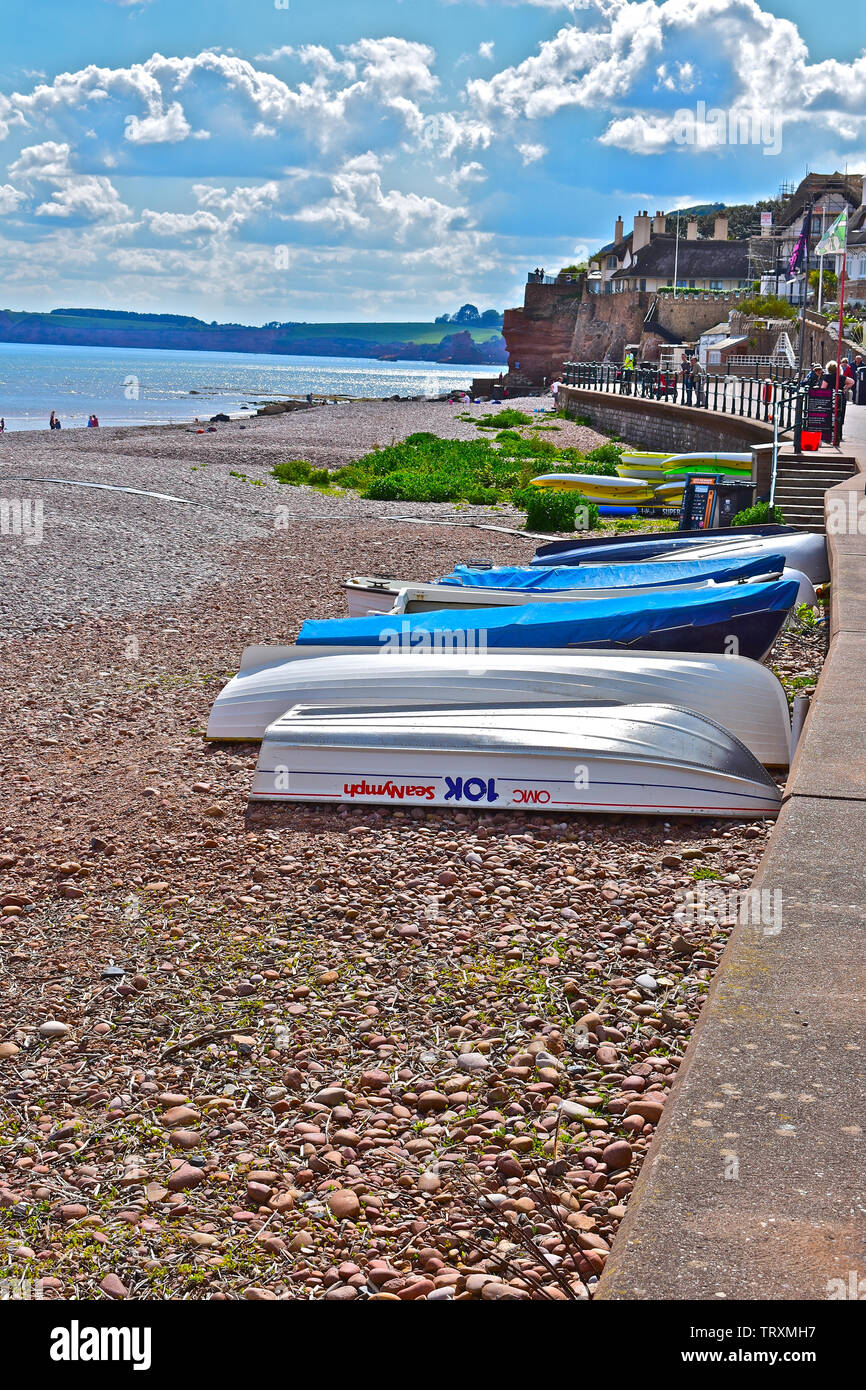 Einen atemberaubenden Blick über den Strand von Sidmouth in Richtung des fernen Küstenlinie der Jurassic Coast, wie es nach Exmouth. Boote im Vordergrund. Stockfoto