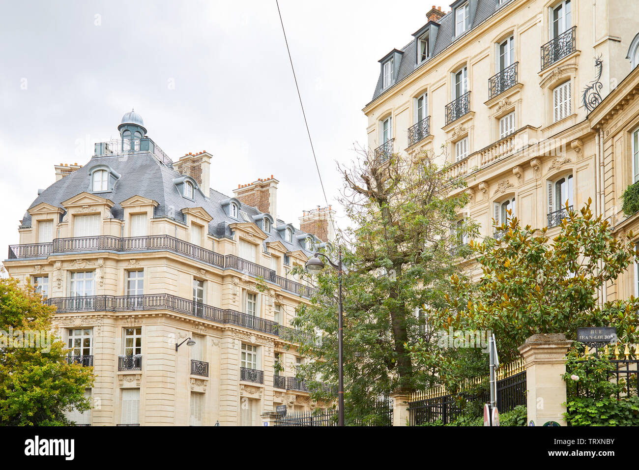 PARIS, Frankreich, 22. JULI 2017: Alte Luxus Gebäude Fassade mit Bäumen und Geländer mit goldenen Punkte in einem bewölkten Tag in Paris, Frankreich Stockfoto
