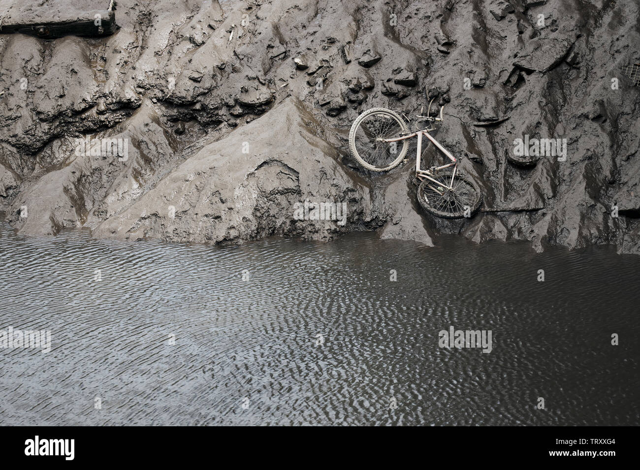 Ein verlassenes Fahrrad- und andere Ablagerungen auf dem schlammigen Ufer des Flusses Team bei Ebbe ausgesetzt Stockfoto
