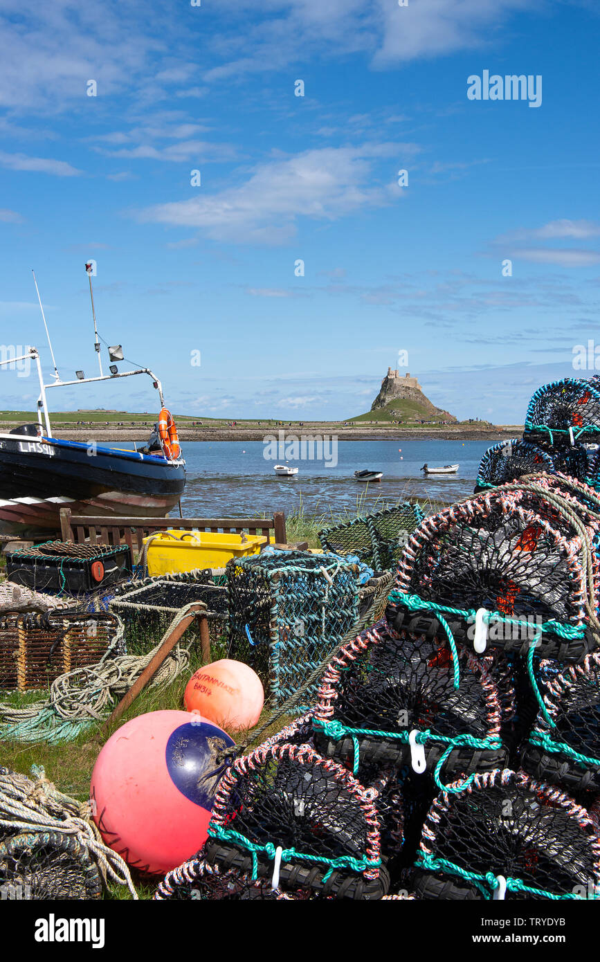 Ein Fischerboot und ein Haufen Hummer und Krabben Töpfe Rahmen Lindisfarne Castle auf Holy Island Northumberland England Vereinigtes Königreich Großbritannien Stockfoto