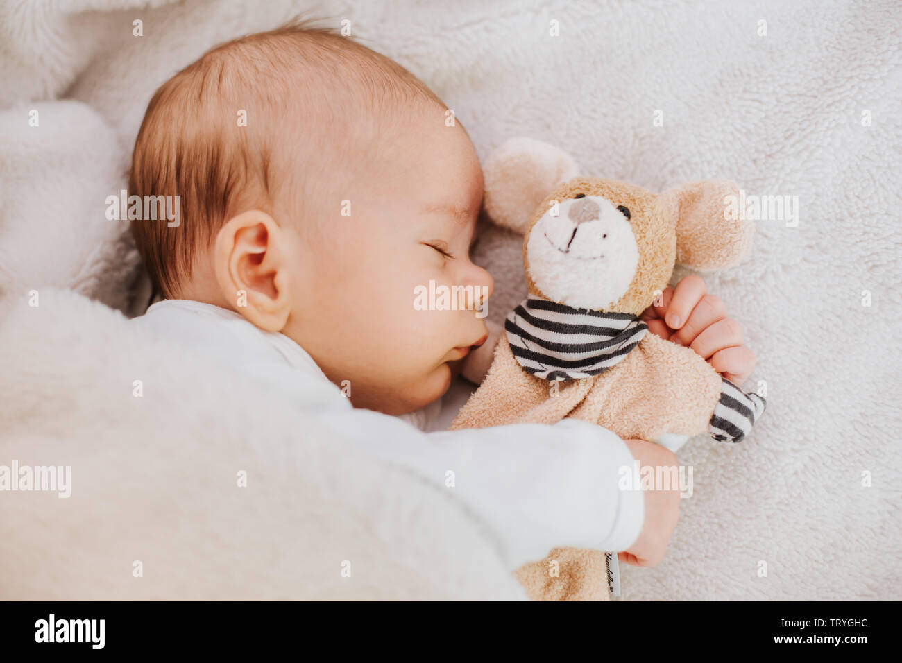 Baby schläft mit stofftier Stockfoto