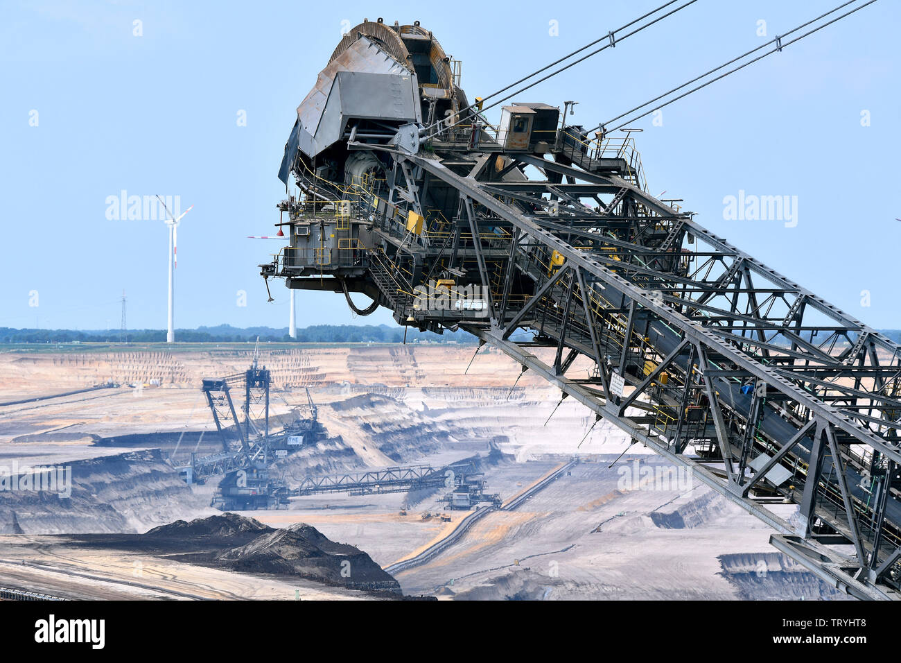 Schaufelradbagger und Windkraftanlagen in der Braunkohle Tagebau Garzweiler im Rheinischen Braunkohletagebaus. Stockfoto
