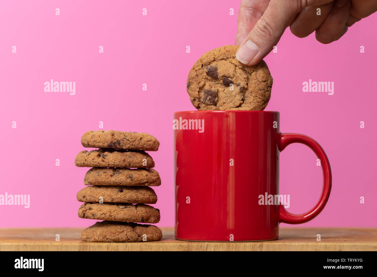 Dunking einen Keks zu einer Tasse Kaffee, Chocolate Chip Cookies. Stockfoto