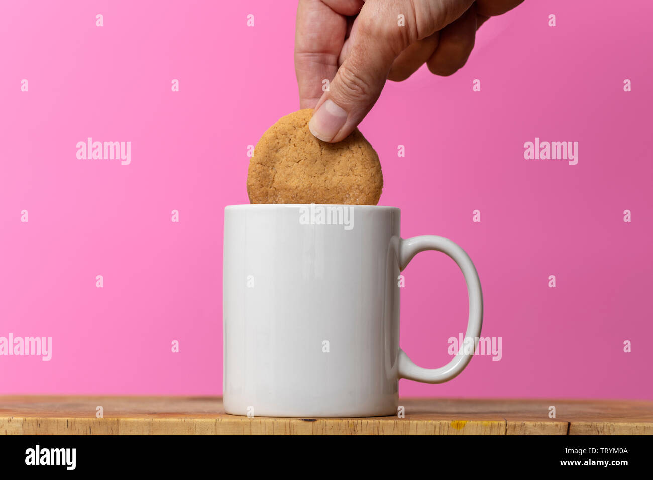 Dunking einen Keks in einer Tasse Kaffee Stockfoto
