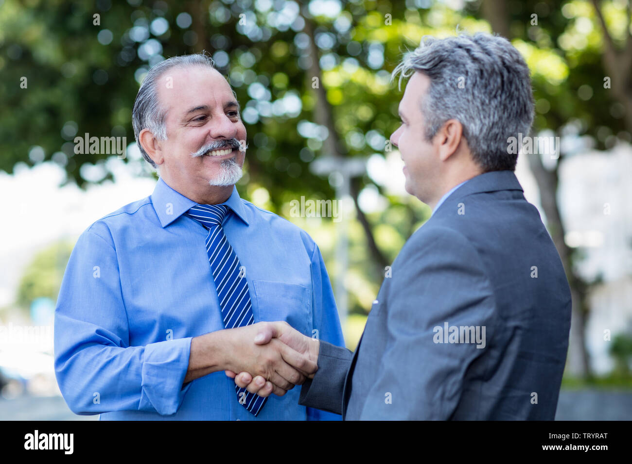 Handshake der älteren Geschäftsmann und reifer Mann im Anzug im Freien in der Stadt Stockfoto