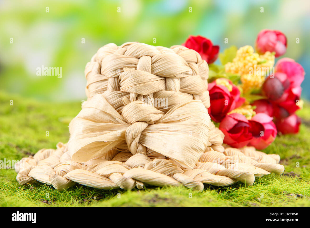 Kleine Stroh Hut mit Blumen, auf grünem Moos Stockfoto