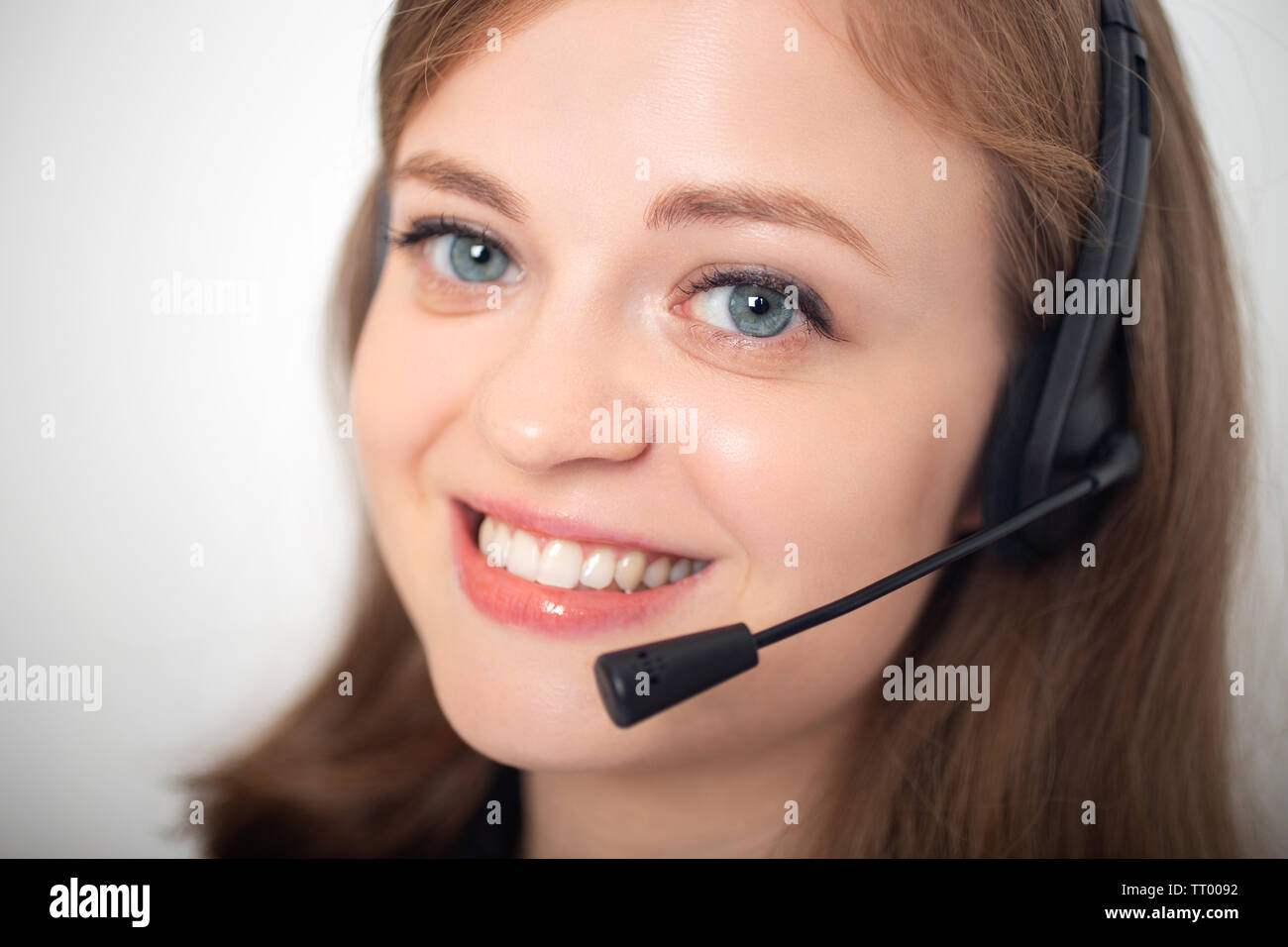 Glücklich lächelnde Junge kaukasier Frau mit Headset Telefon im Call Center oder im Büro, in der Nähe von Stockfoto