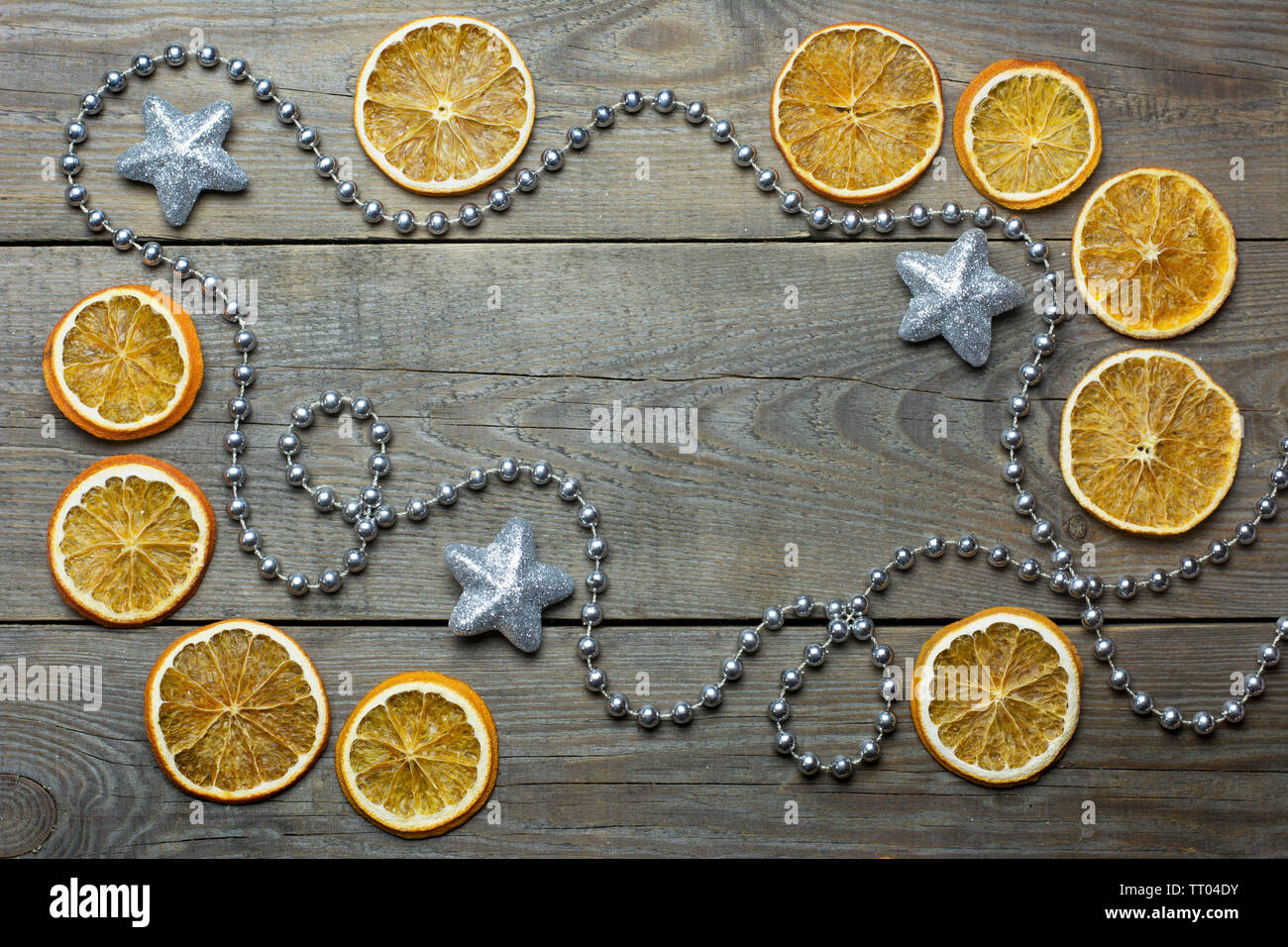 Weihnachten Zusammensetzung mit silbernen Perlen Kette, Brocade Sterne und Orangenscheiben auf hölzernen Hintergrund Stockfoto