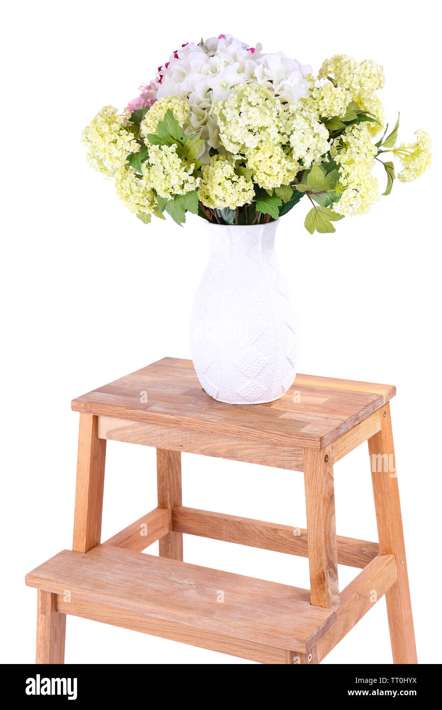 Vase mit Blumen auf kleinen Holzleiter, isoliert auf weißem Stockfoto