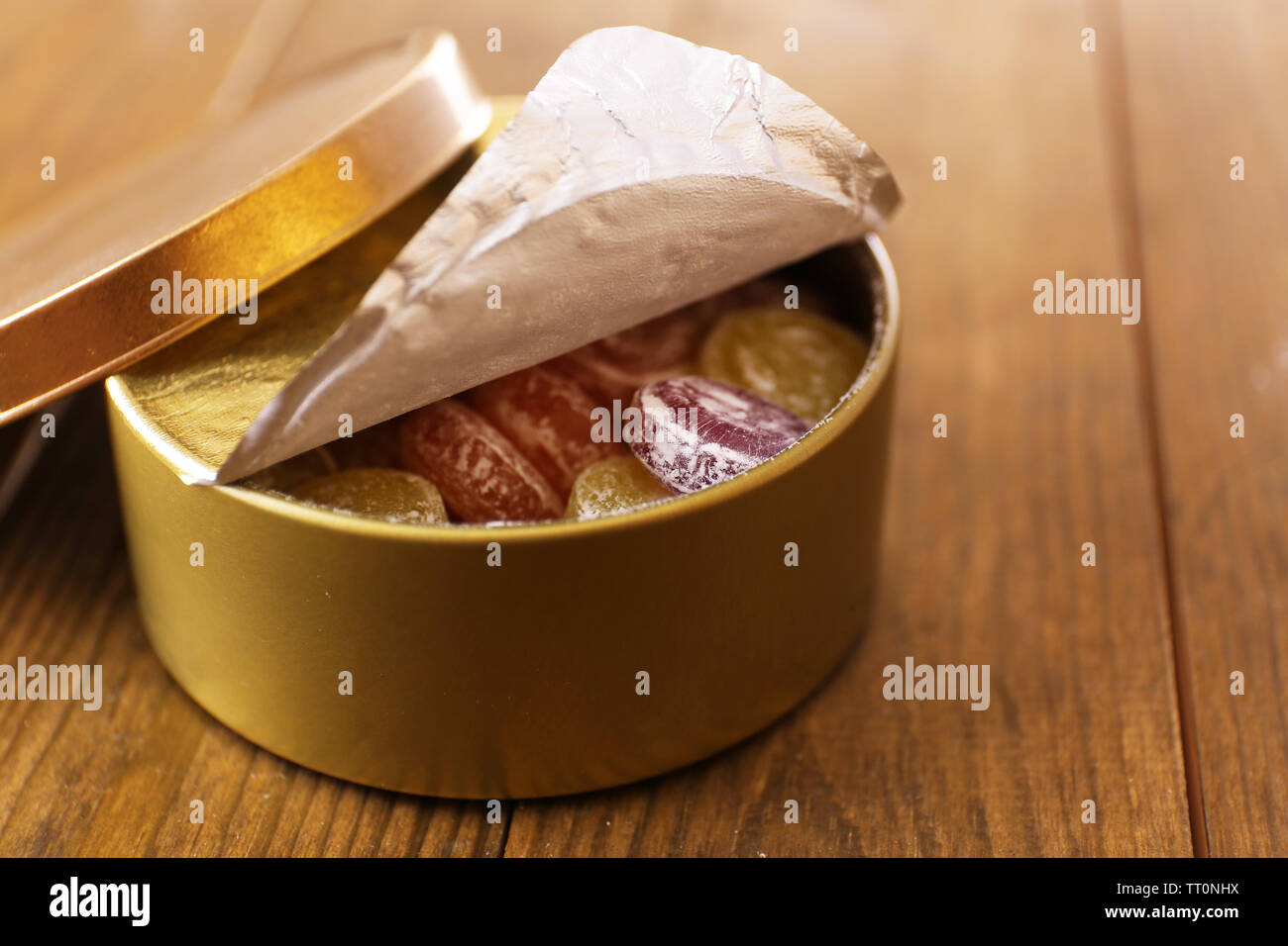 Süße Bonbons in Metall, Holz- Hintergrund Stockfoto