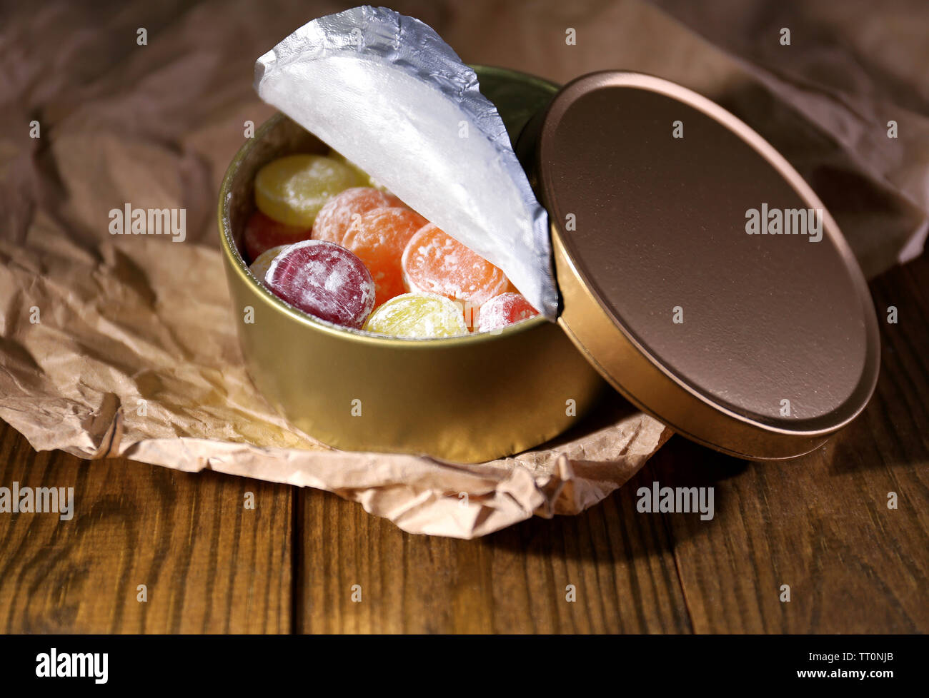 Süße Bonbons in Metall, Holz- Hintergrund Stockfoto