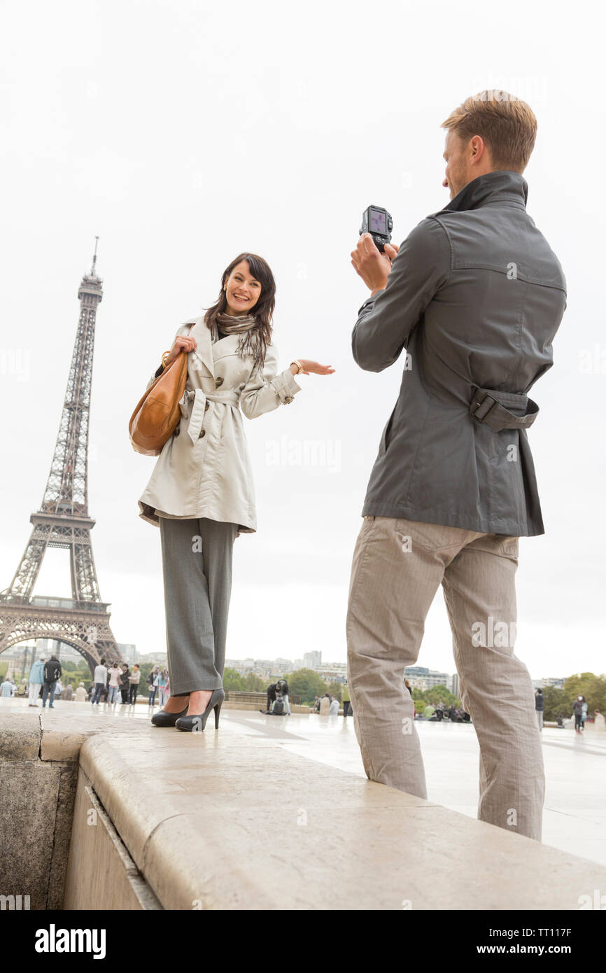 , Junges Paar Touristen Spaß in Paris. Mann fotografieren Frau in der Nähe des Eiffelturms. Stockfoto