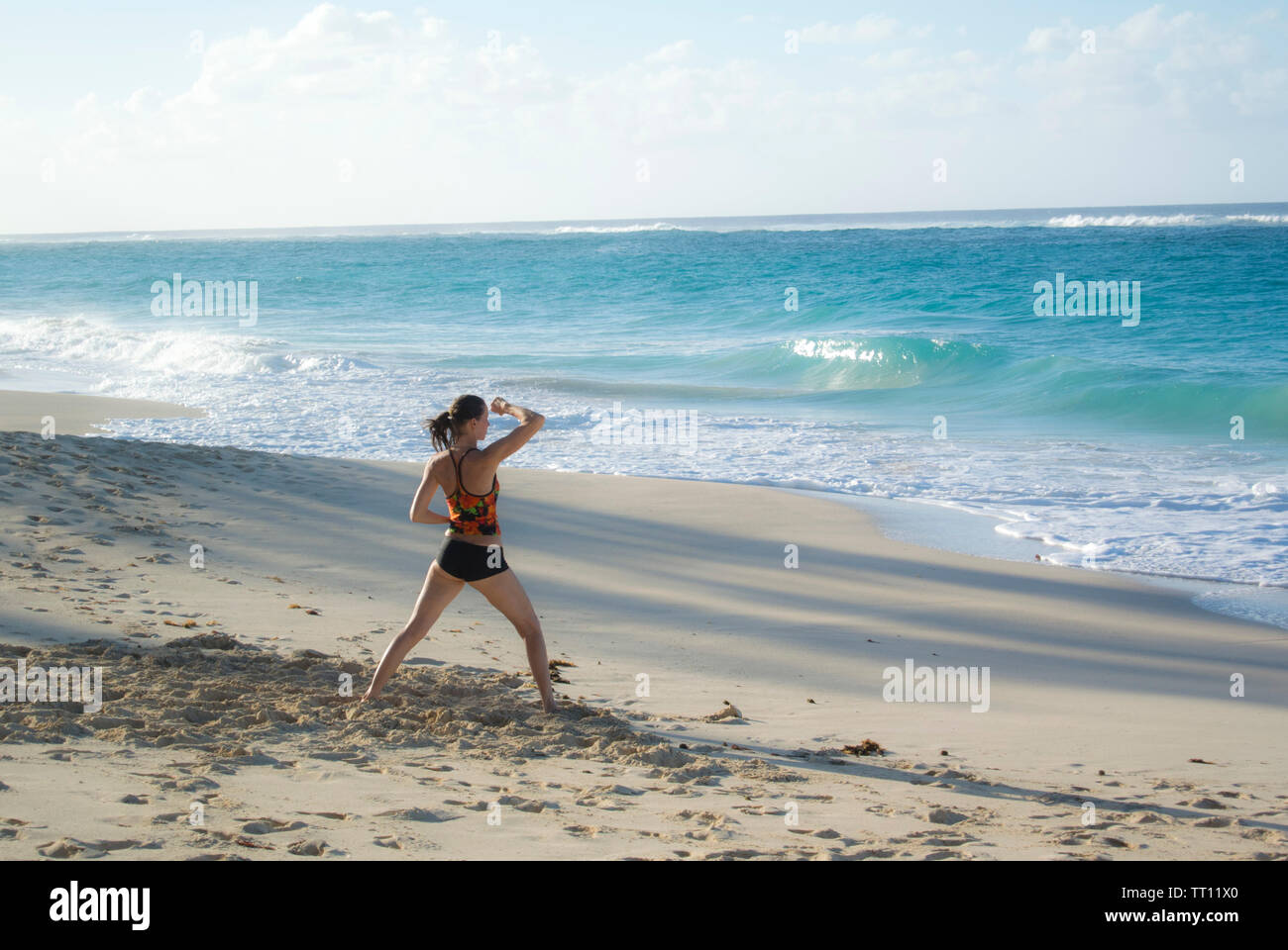 Frau übt Tai-Chi am Strand Stockfoto