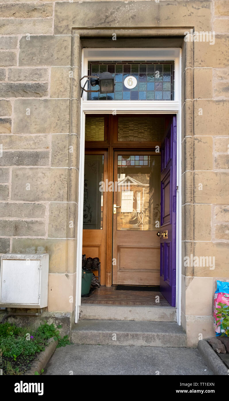 Traditionelle lila hölzerne Tür, öffnen, in eine Mauer aus Stein an einem Haus (Nummer 6) in der viktorianischen Vorstadt Morningside, Edinburgh, Schottland, Großbritannien Stockfoto