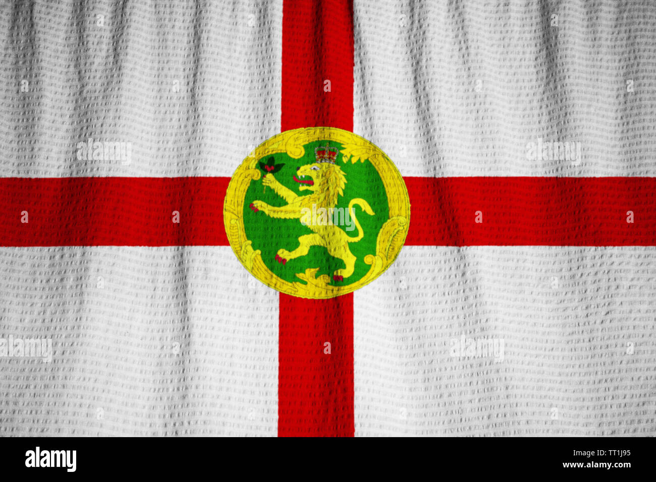 Zerzauste Fahne von Alderney weht im Wind Stockfoto