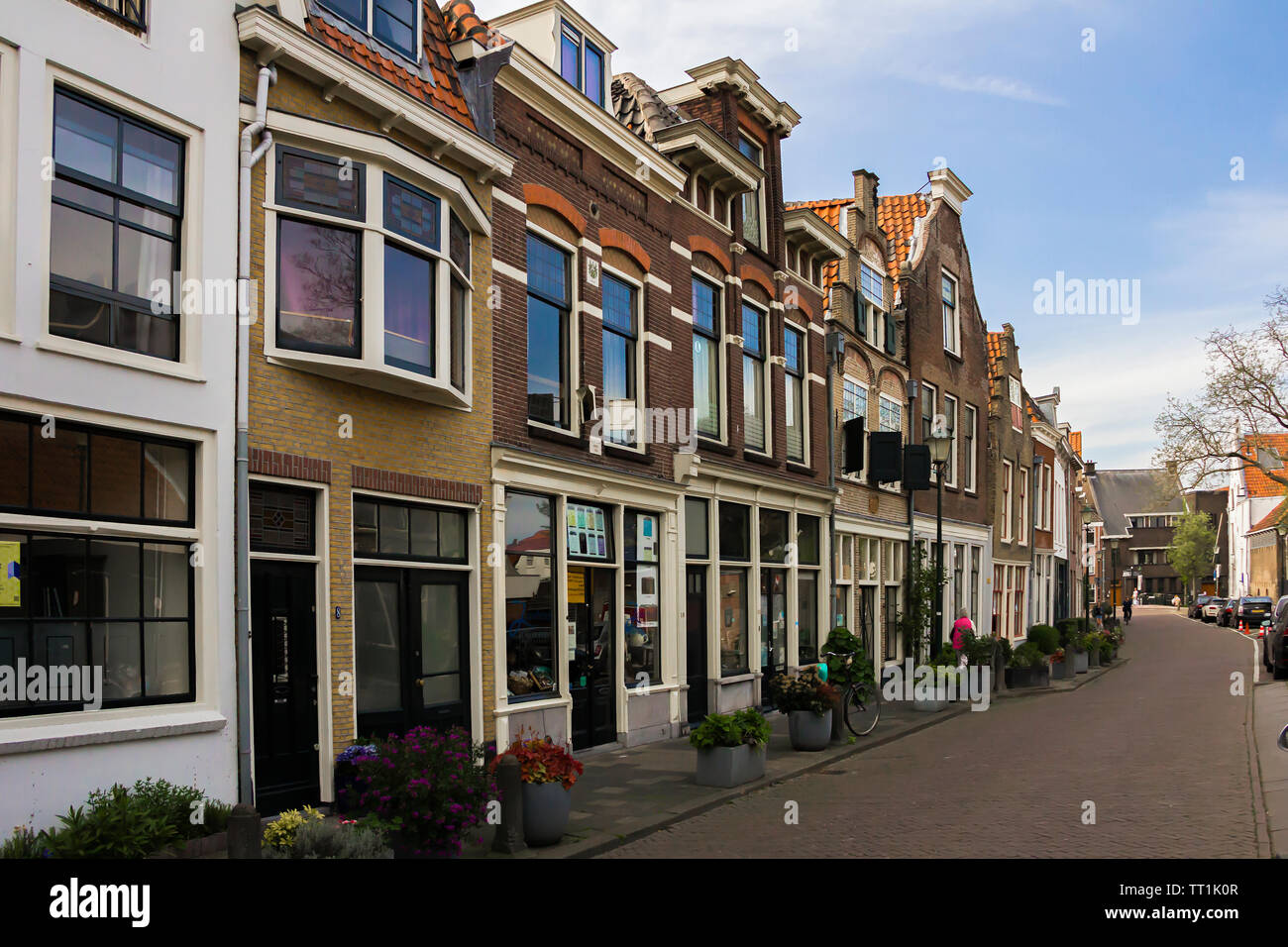 Gouda, Holland, Niederlande, April 23, 2019, Fahrräder und in der Nähe einer Brücke entlang einer Straße geparkt, Canal in Gouda Altstadt. Blumen in einem blumenbeete, Boot Stockfoto