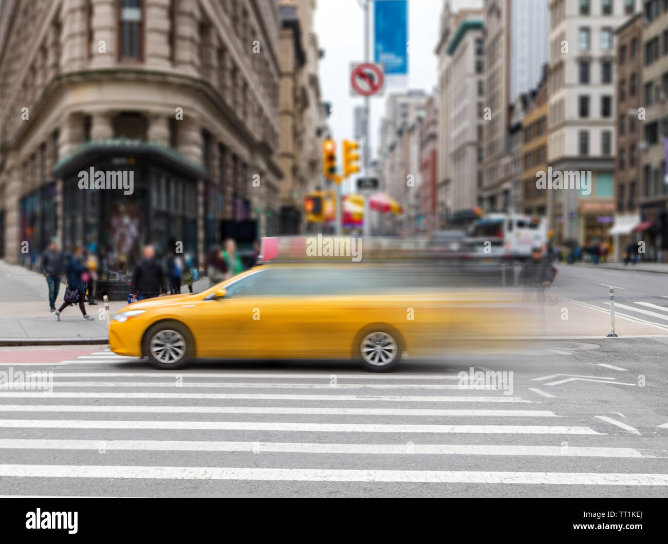 Motion Blur von gelben Taxi durch einen Schnittpunkt auf der 23. Straße in Manhattan, New York City NYC Beschleunigung Stockfoto