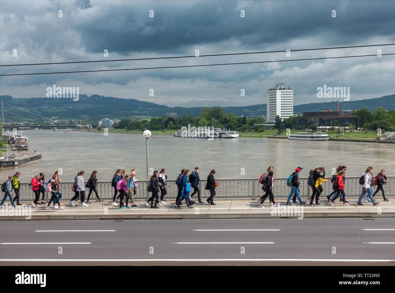 Linz Nibelungenbrücke über der Donau mit Studenten, River Cruise Boote und Arcotel Nike. Nibelungenbrücke Linz Österreich Österreich. Stockfoto