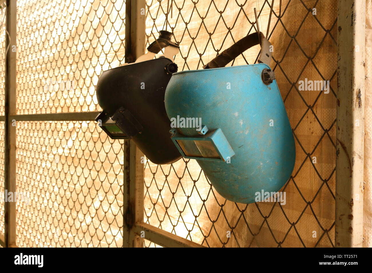 Nahaufnahme des Schweißen Masken hängen an den Zaun des Arbeitsbereichs, Sicherheitskonzept Stockfoto