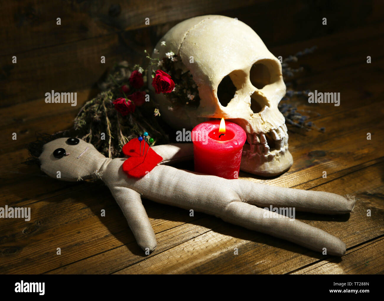 Konzeptionelle Foto Liebe Magie. Komposition mit Totenkopf, Voodoo-Puppe,  getrocknete Kräuter und Kerze auf dunklem Holz Stockfotografie - Alamy