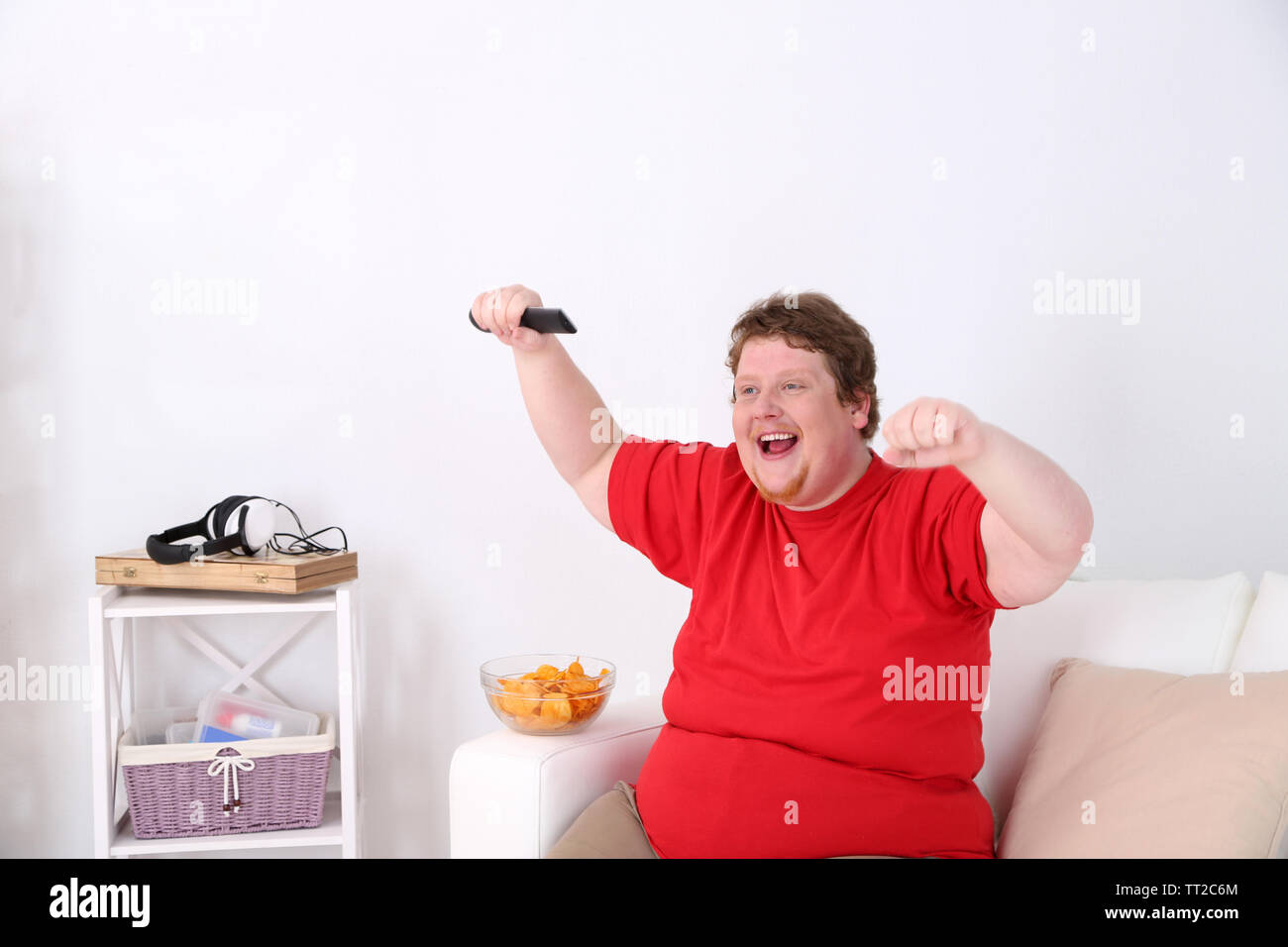 Faul übergewichtige Männer sitzen auf der Couch und Fernsehen Stockfotografie