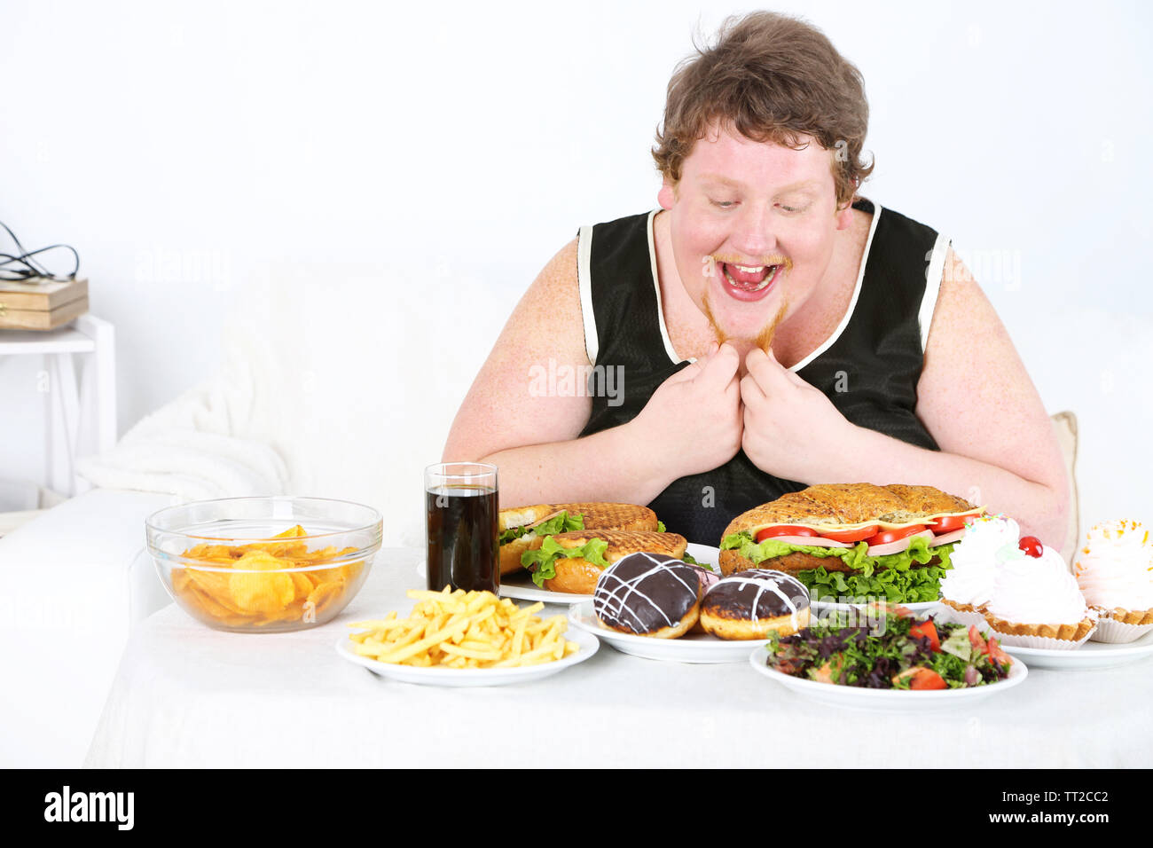 Fat Man hat ein großes Mittagessen, an Home Interior Hintergrund Stockfoto