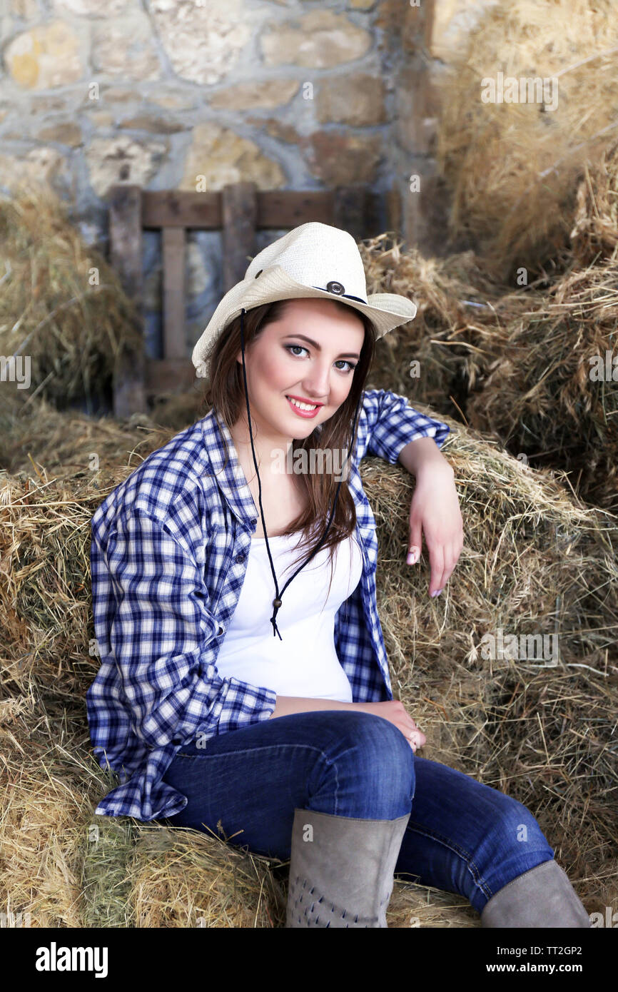 Schöne cowgirl Modell posiert auf landwirtschaftlich genutzten Flächen. Stockfoto