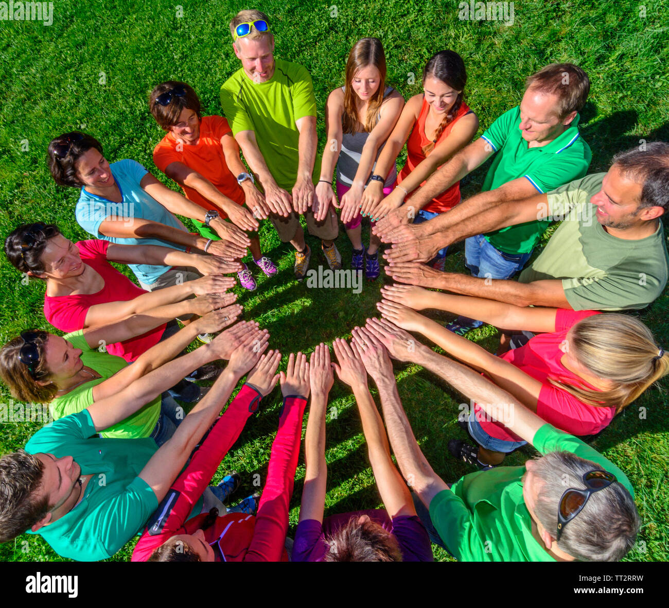 Eine Gruppe von Menschen, die ihre Verbundenheit während einer Teambuilding-Übung in der Natur demonstrieren Stockfoto