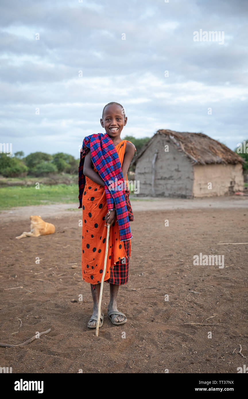 Gleichen, Tansania, 7. Juni, 2019: junge Maasai kid in der Boma, mit seinem Haus im Hintergrund Stockfoto