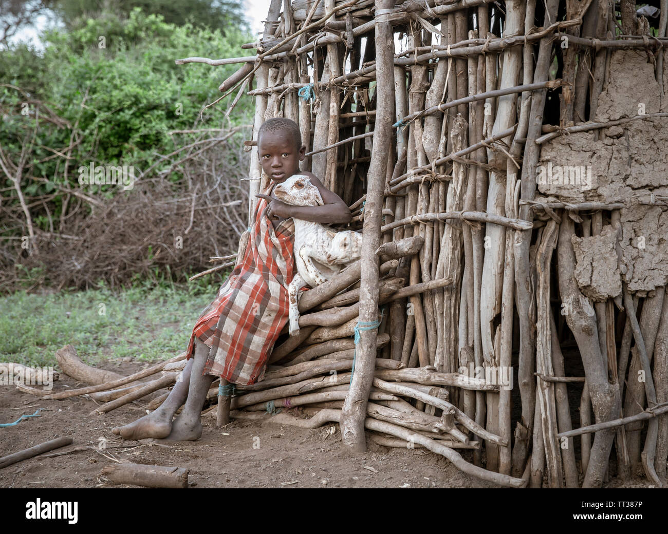 Gleichen, Tansania, 5. Juni, 2019: Masai junge halten Baby Ziegen aus ihrem Haus zu entkommen Stockfoto