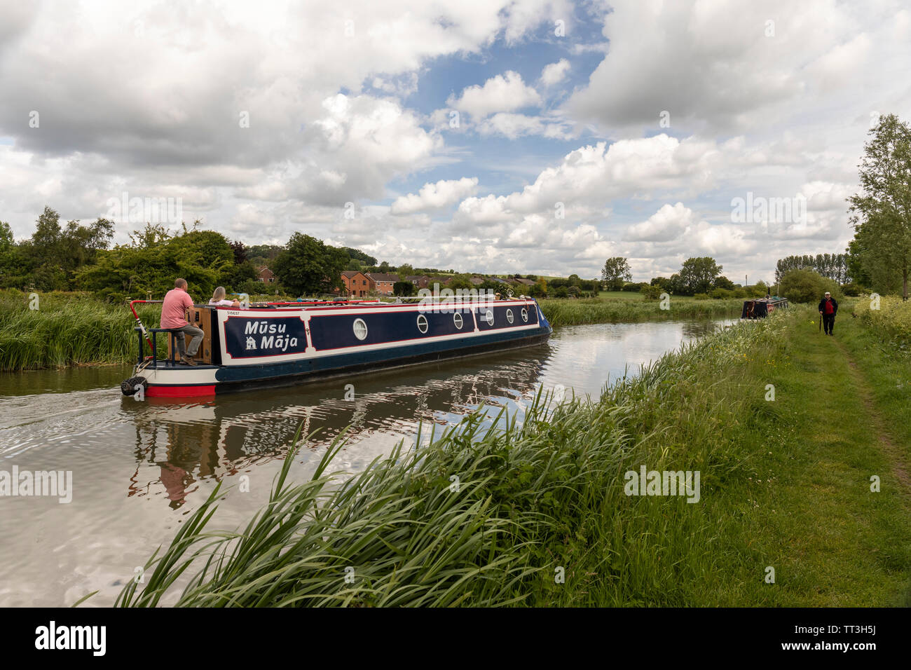 Ein Kanalboot und Spaziergänger - der Kennet und Avon Kanal in Great Bedwyn, Wiltshire, England, Großbritannien Stockfoto