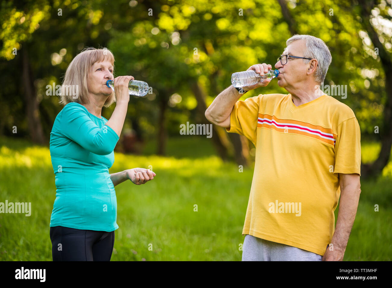 Gerne älteres Paar ist Trinkwasser nach dem Training im Park. Stockfoto
