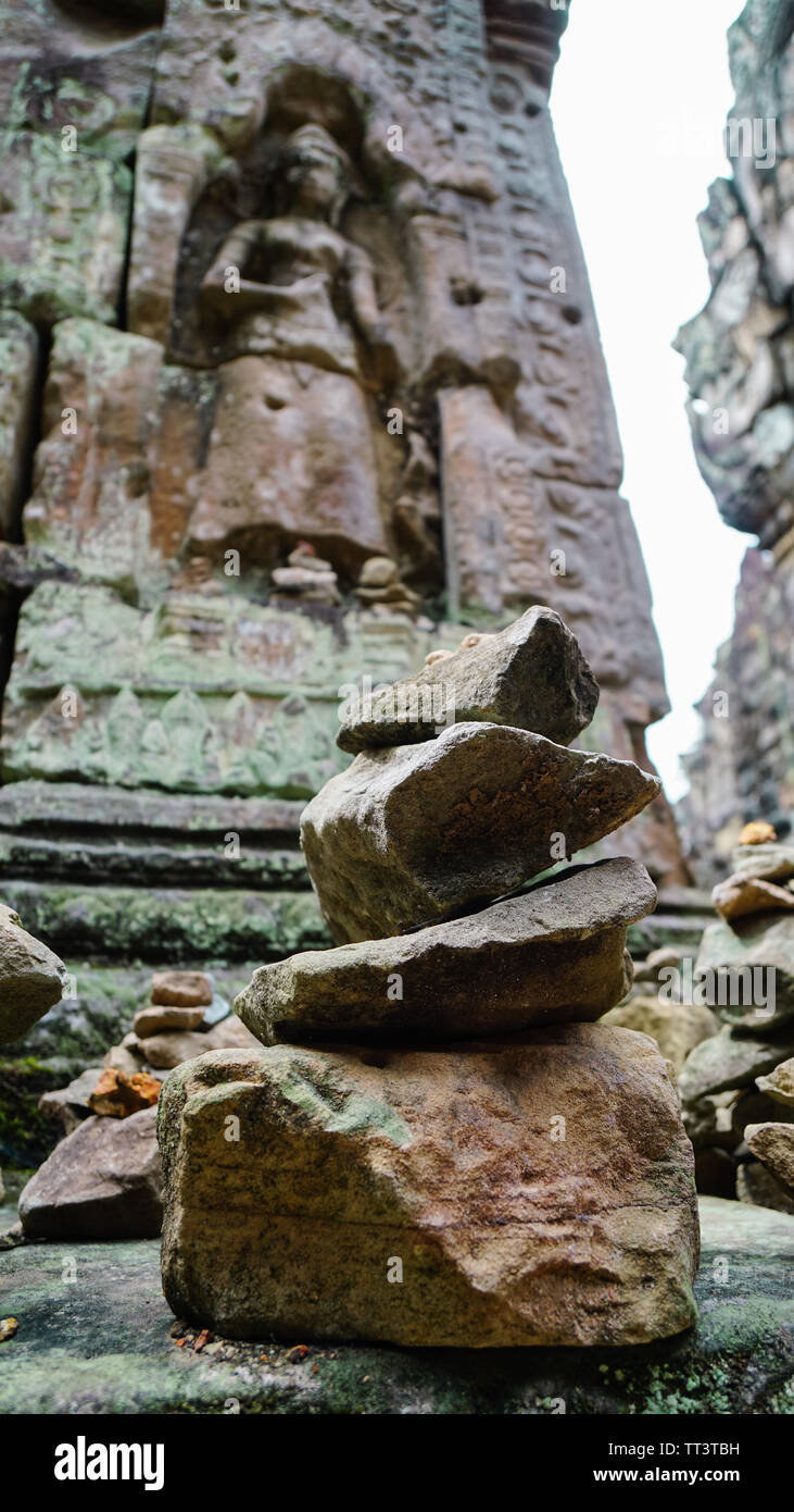 Nahaufnahme eines Stapels von Steinen mit religiöser Bedeutung und ein unscharfes antiken Skulptur im Hintergrund, in der schönen Bayon Tempel Schuß - ein decorat Stockfoto