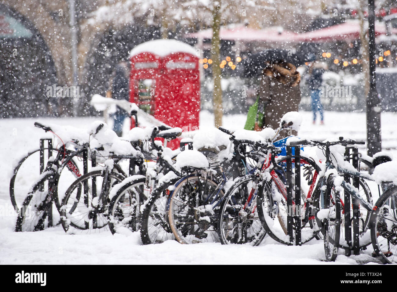 Badewanne, Somerset, Februar, 01, 2019. Starker Schneefall in der Badewanne: Shopper Wandern im Schnee der Vergangenheit eine Reihe von Schnee bedeckt Fahrräder in der Nähe von Bath Bahnhof. Stockfoto