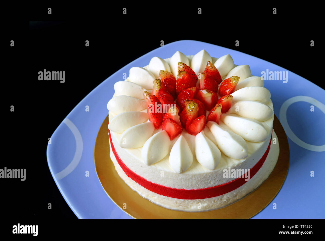 Frische Erdbeere Vanille kurze Kuchen serviert auf Blau Keramik Fach isoliert auf schwarzem Hintergrund Stockfoto