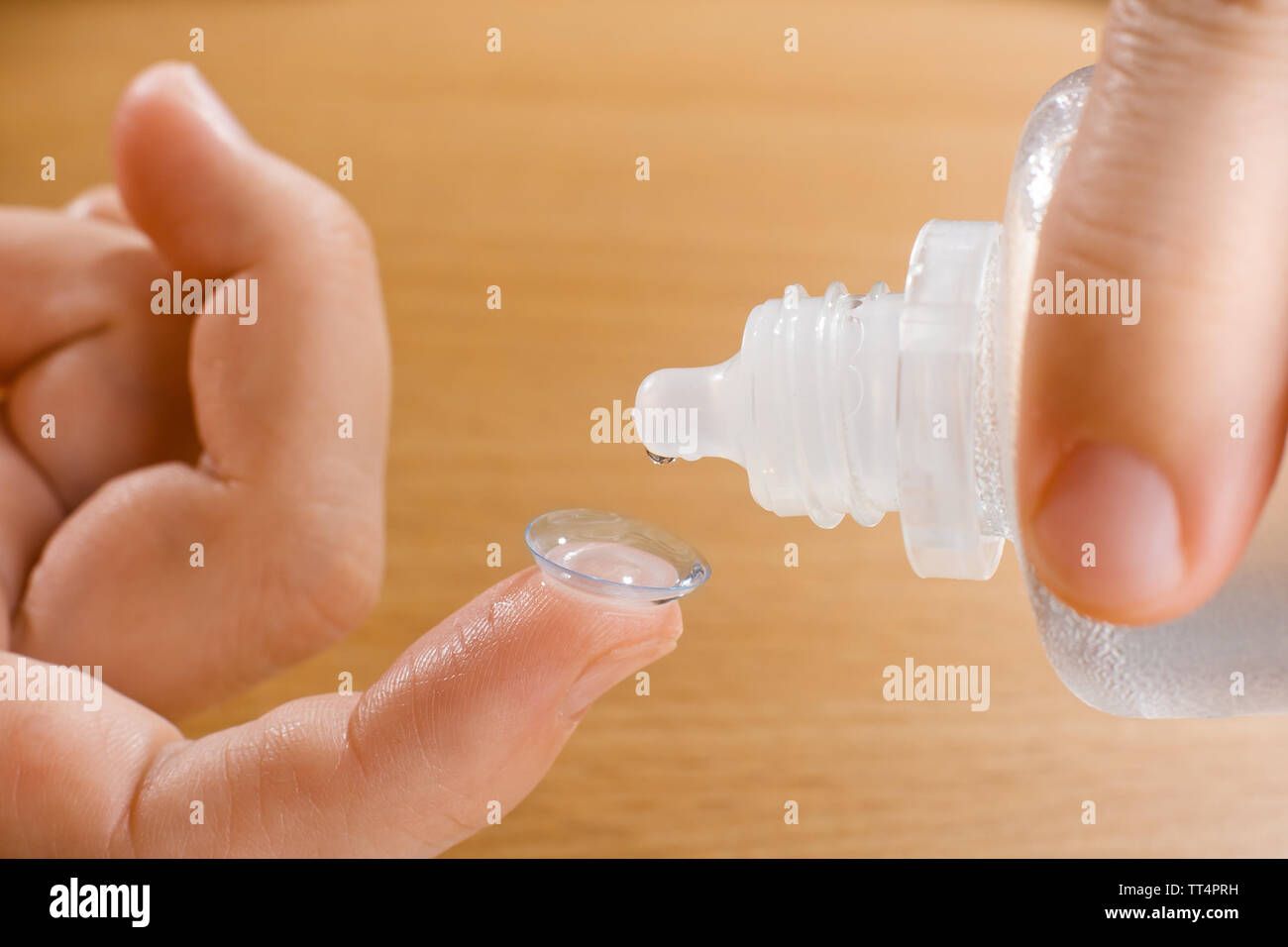Hände von Frau waschen Kontaktlinse mit Lösung, Nahaufnahme Stockfoto