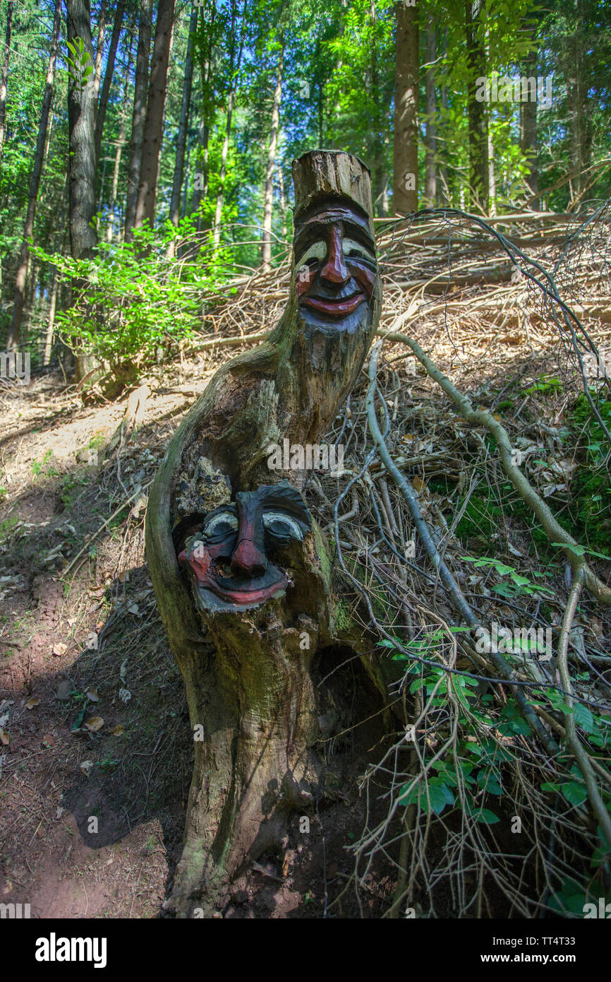 Geschnitzte Gesichter in einem Baumstamm, Wald Geister Trail (deutsch: Waldgeisterweg), Oberotterbach, Deutsche Weinstraße, Rheinland-Pfalz, Deutschland Stockfoto