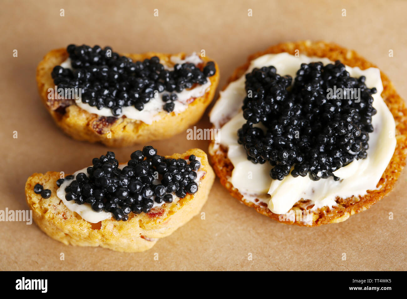 Scheiben Brot mit Butter und schwarzen Kaviar auf Papier Hintergrund Stockfoto