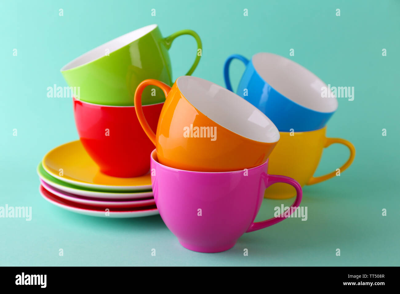 Bunte Tassen und Untertassen auf farbigen Hintergrund Stockfotografie -  Alamy