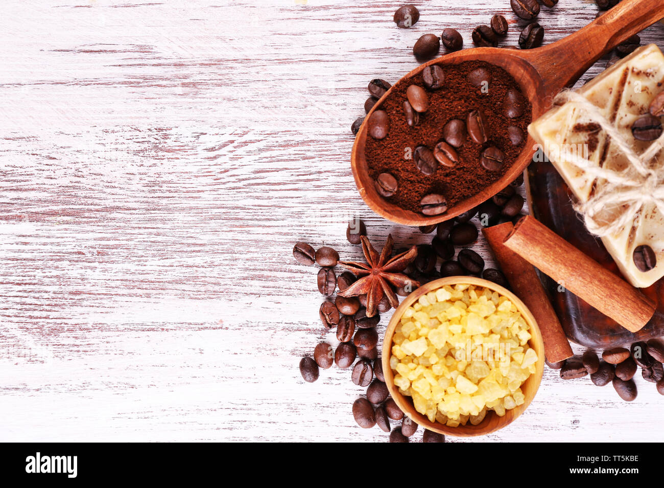 Organische Seife mit Kaffeebohnen, Meersalz und gemahlenen Kaffee in hölzernen Löffel auf Geflochtenen Matte, auf hölzernen Hintergrund, Kaffee spa-Konzept Stockfoto