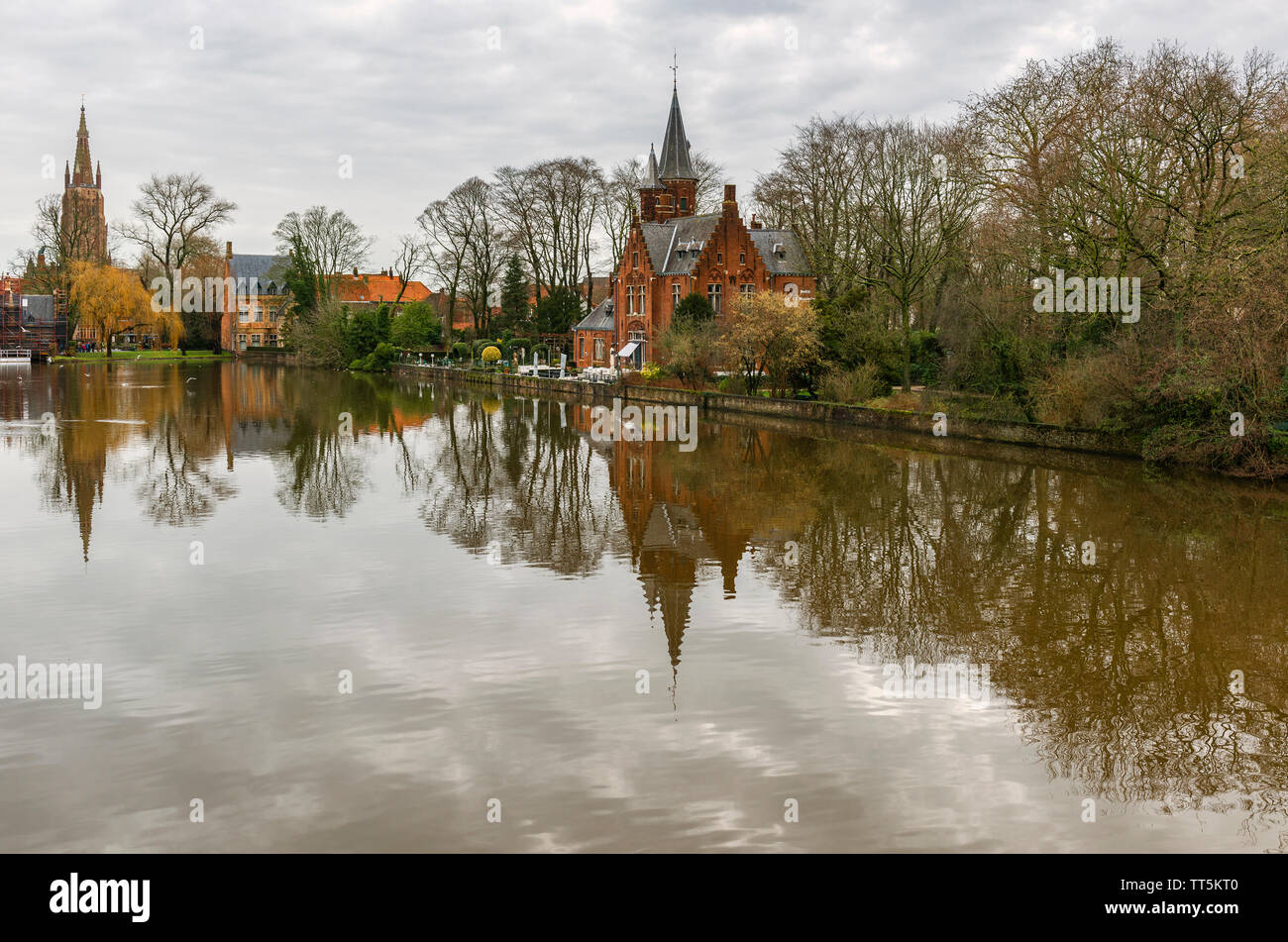 Die minnewater See oder See der Liebe im Zentrum von Brügge und eine Reflexion einer mittelalterlichen Burg und der Muttergottes Kirche, Westflandern, Belgien. Stockfoto