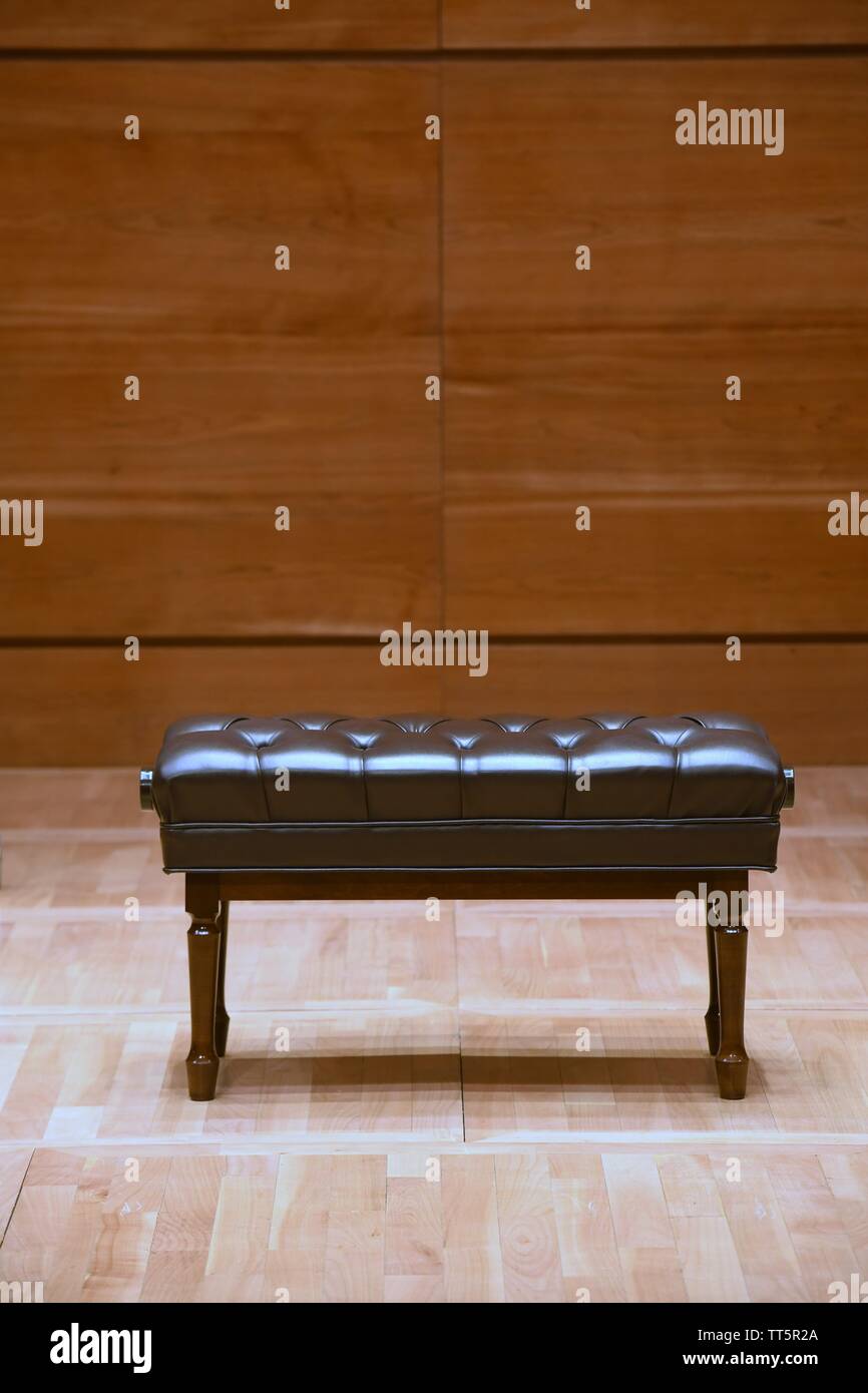 Braun Holz- Klavier Hocker auf dem hölzernen Bühne in Concert Hall Stockfoto