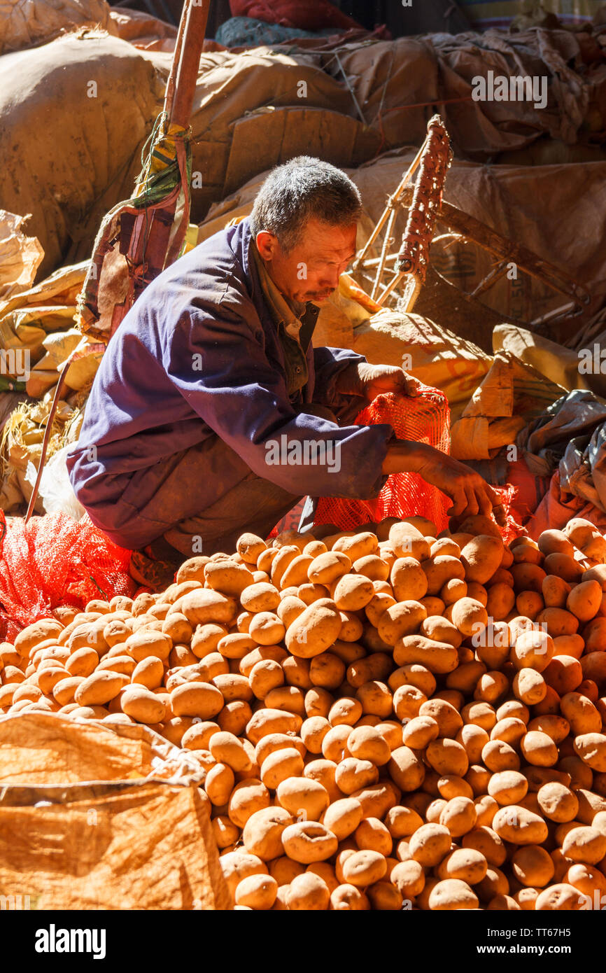 01 Feb 2017 - Dali, China Mann Kartoffeln zum Verkauf vorbereitet Stockfoto
