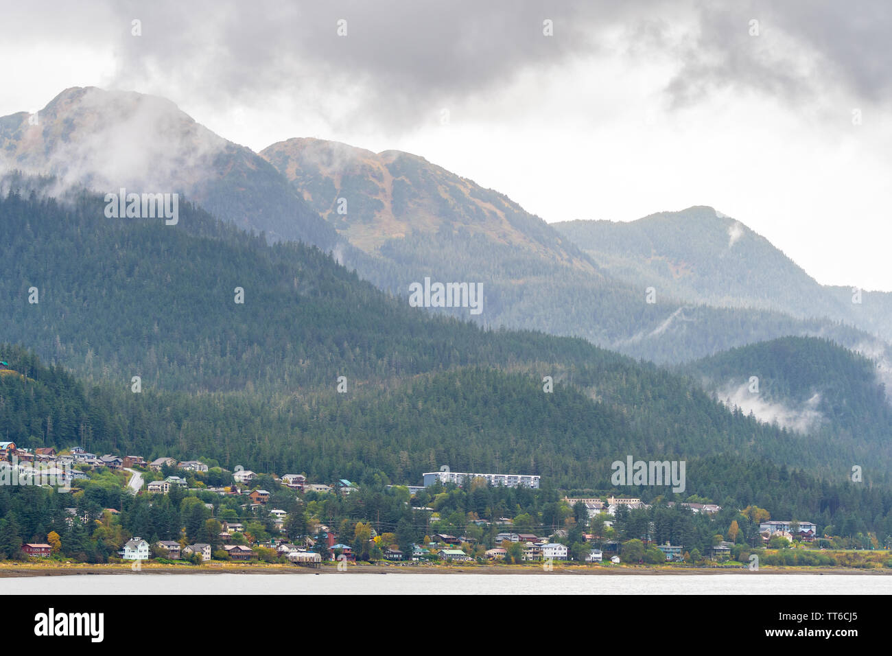 Malerische Berglandschaften in Juneau, Alaska. Gemeinschaft der Wohnungen/Häuser und großen kommerziellen Bürogebäuden und Schulen am Fuße des Berges. Stockfoto